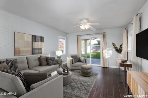 a living room with furniture wooden floor and a flat screen tv