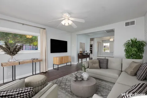 a living room with furniture a flat screen tv and a large window