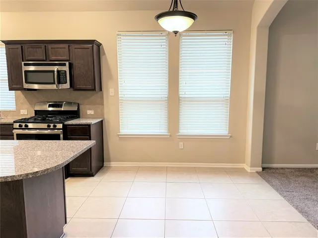 a kitchen with stainless steel appliances granite countertop a sink and a stove
