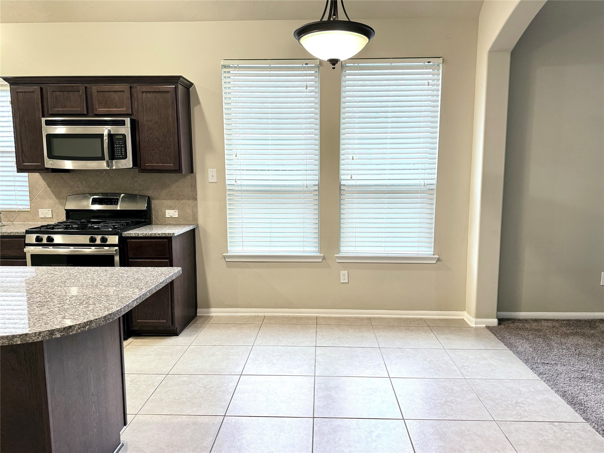 21907 Cascade Hollow Lane Spring, TX 77379 - Photo 16 of 40 a kitchen with a stove a sink and a microwave