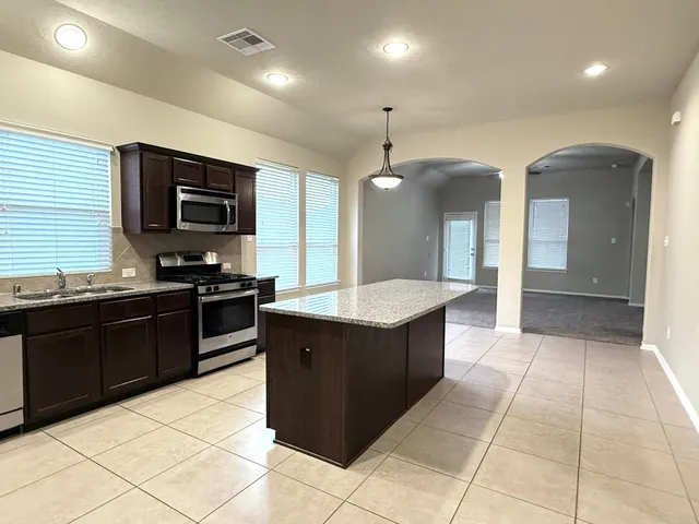 a kitchen with stainless steel appliances granite countertop a stove and a sink