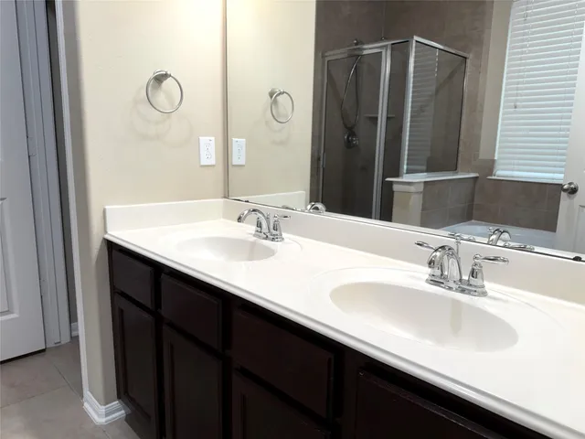 a bathroom with double vanity sink and a mirror