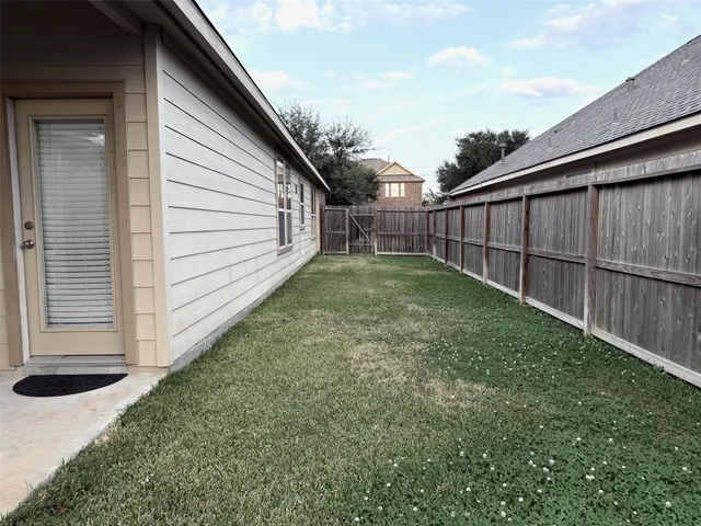 a view of a backyard with wooden fence