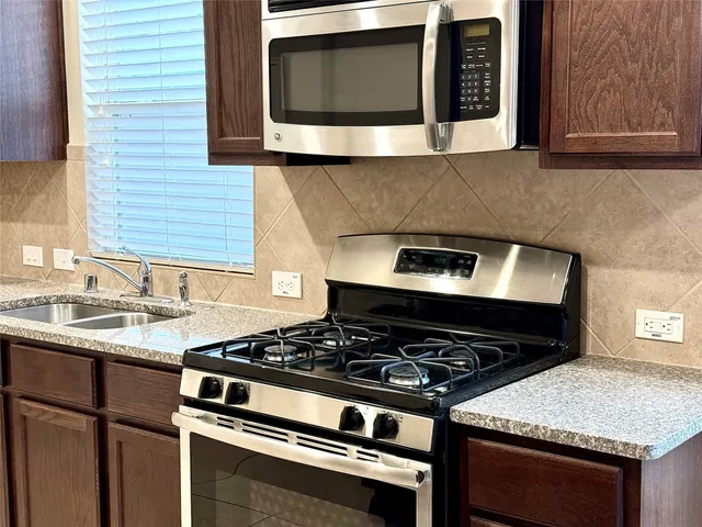 a stove top oven sitting inside of a kitchen