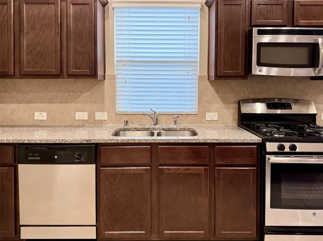 a kitchen with granite countertop a stove and a microwave