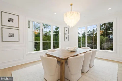 a dining room with stainless steel appliances granite countertop furniture and a large window