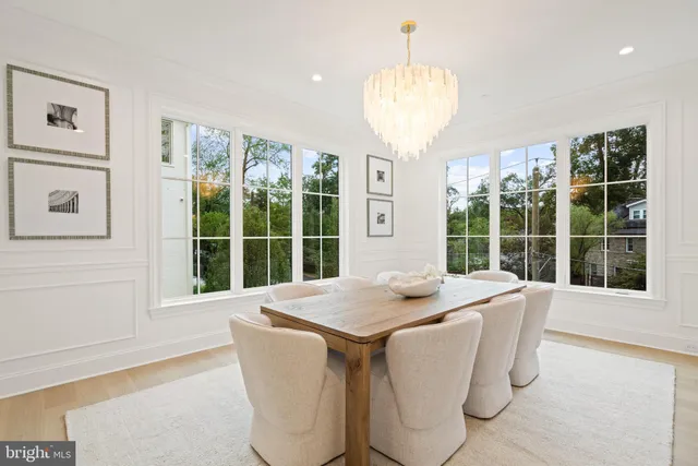 a dining room with stainless steel appliances granite countertop furniture and a large window
