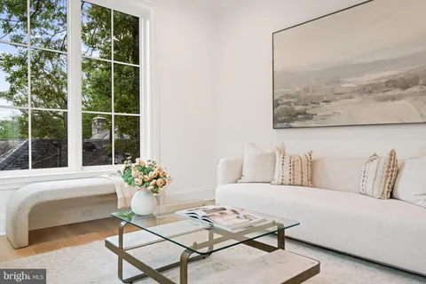 a living room with a large window and floor to ceiling windows