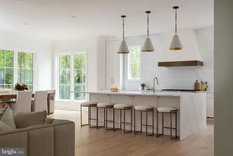 a large white kitchen with a large window and stainless steel appliances