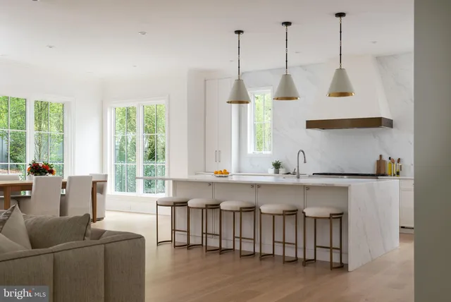 a large white kitchen with a large window and stainless steel appliances