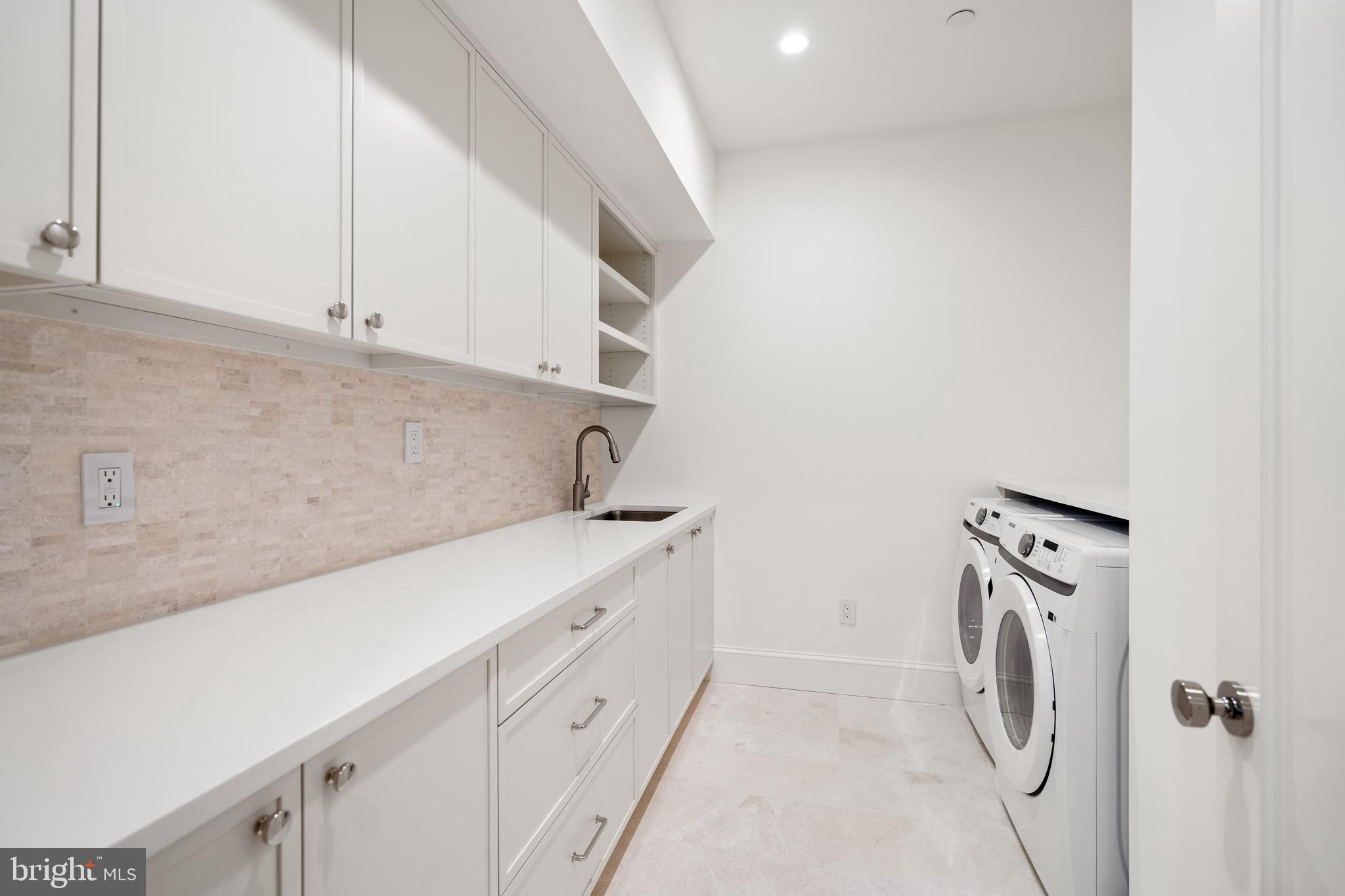 2916 Chesapeake Street Northwest Washington, DC 20008 - Photo 32 of 54 a utility room with cabinets washer and dryer