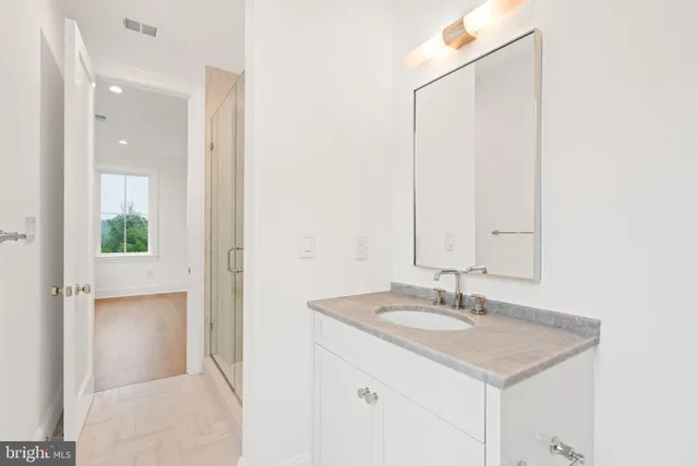 a bathroom with a toilet a sink a mirror and a shower