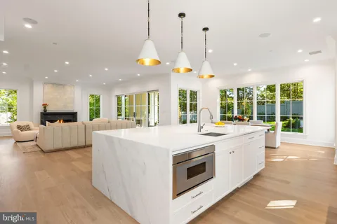 a large kitchen with kitchen island a large window a sink and stainless steel appliances
