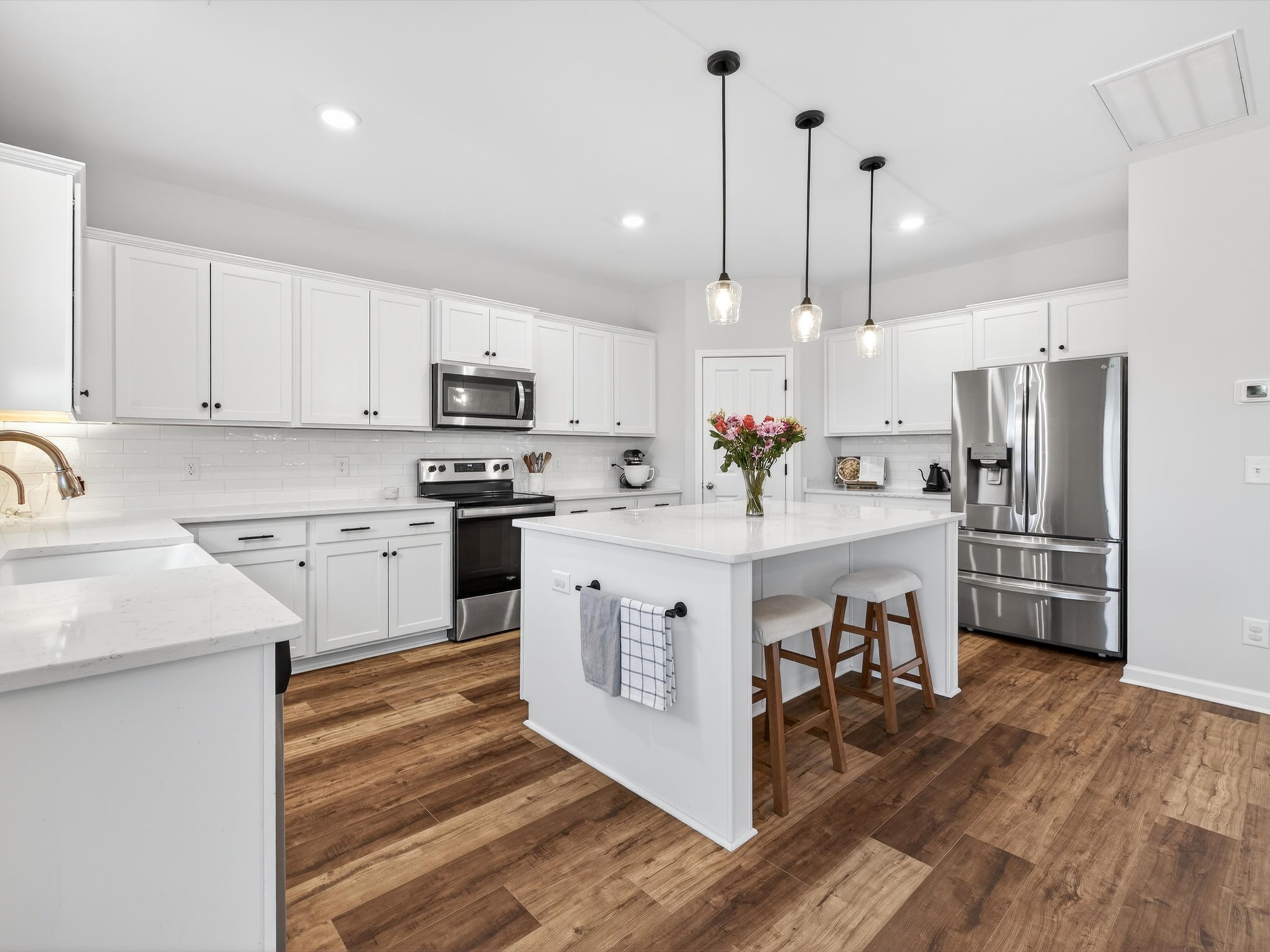 409 Rangeland Road Spring Hill, TN 37174 - Photo 16 of 75 a kitchen with white cabinets and stainless steel appliances