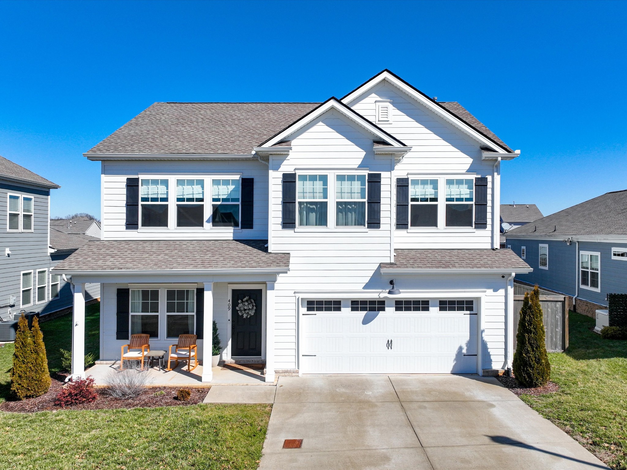 409 Rangeland Road Spring Hill, TN 37174 - Photo 64 of 75 a view of a white house with large windows and a table and chairs in patio