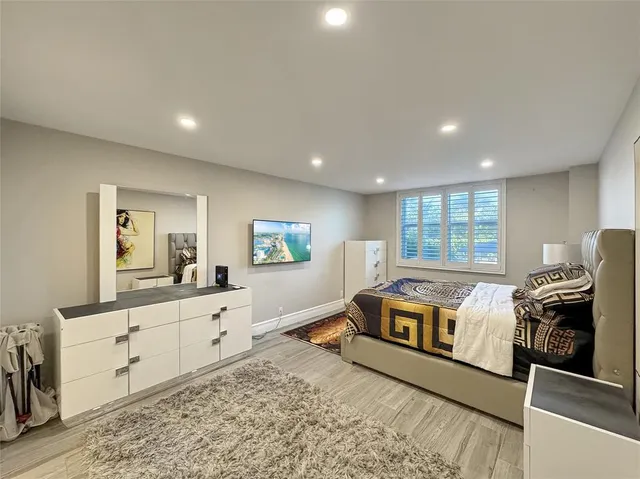 a spacious bedroom with a bed and a view of kitchen