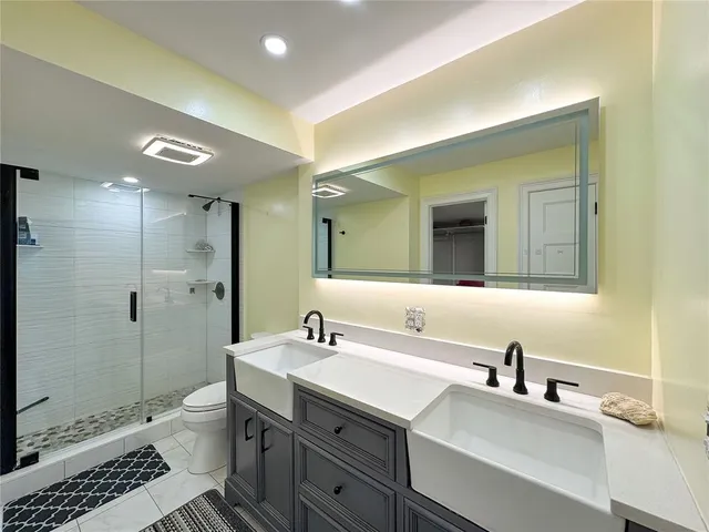 a bathroom with a sink a toilet and shower