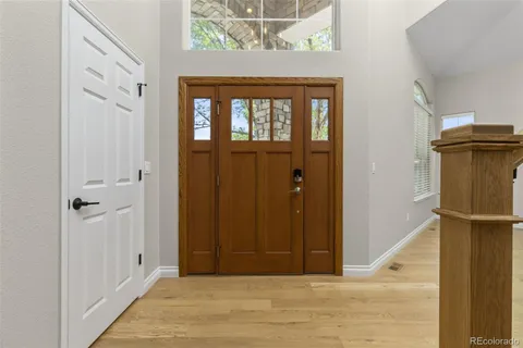 a view of a hallway with wooden floor and entryway