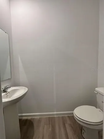 a white toilet sitting next to a white sink and vanity