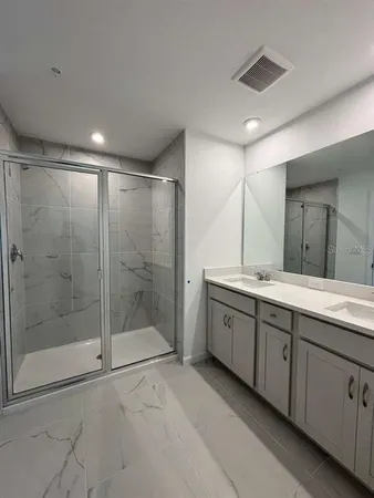 a bathroom with a shower sink and mirror