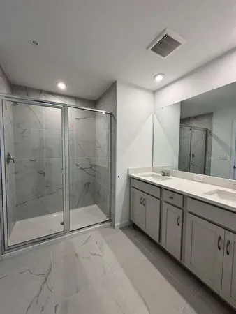a bathroom with a shower sink and mirror