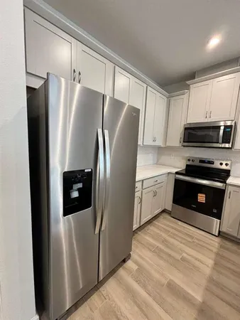 a kitchen with stainless steel appliances and refrigerator