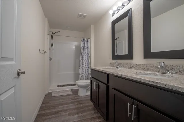 a bathroom with a granite countertop sink toilet and shower