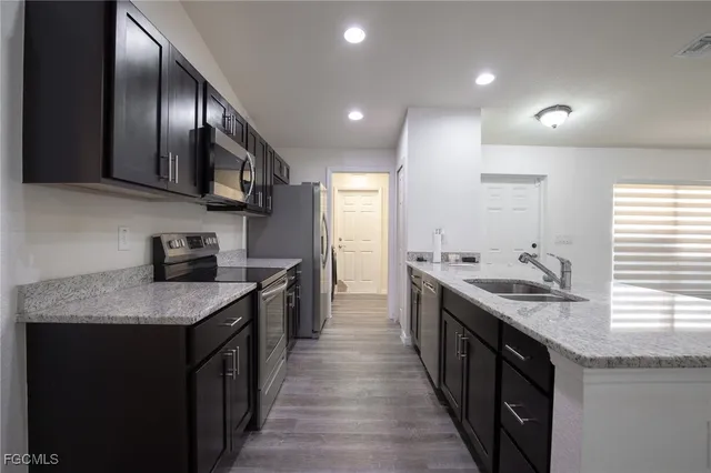 a kitchen with stainless steel appliances granite countertop a sink stove and cabinets