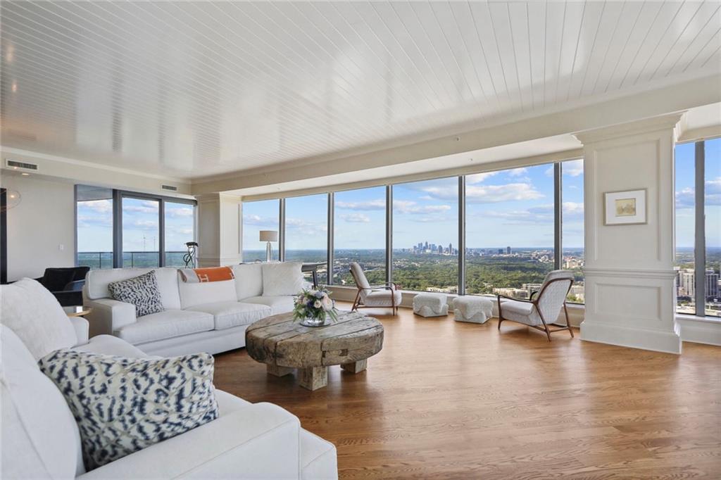 a living room with fireplace furniture and floor to ceiling windows