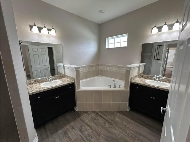a spacious bathroom with a bathtub sink and view