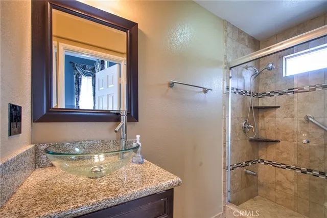 a bathroom with a granite countertop sink and a mirror