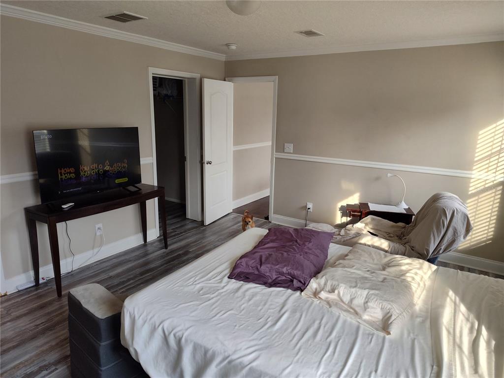 9811 Bud Street Hudson, FL 34669 - Photo 15 of 53 a bedroom with a bed and a flat screen tv