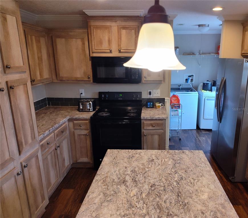 9811 Bud Street Hudson, FL 34669 - Photo 18 of 53 a kitchen with kitchen island granite countertop wooden cabinets a sink a stove and a wooden floors