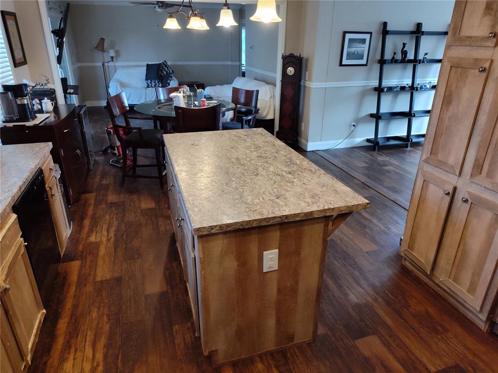 9811 Bud Street Hudson, FL 34669 - Photo 21 of 53 a living room with wooden floor and a book shelf