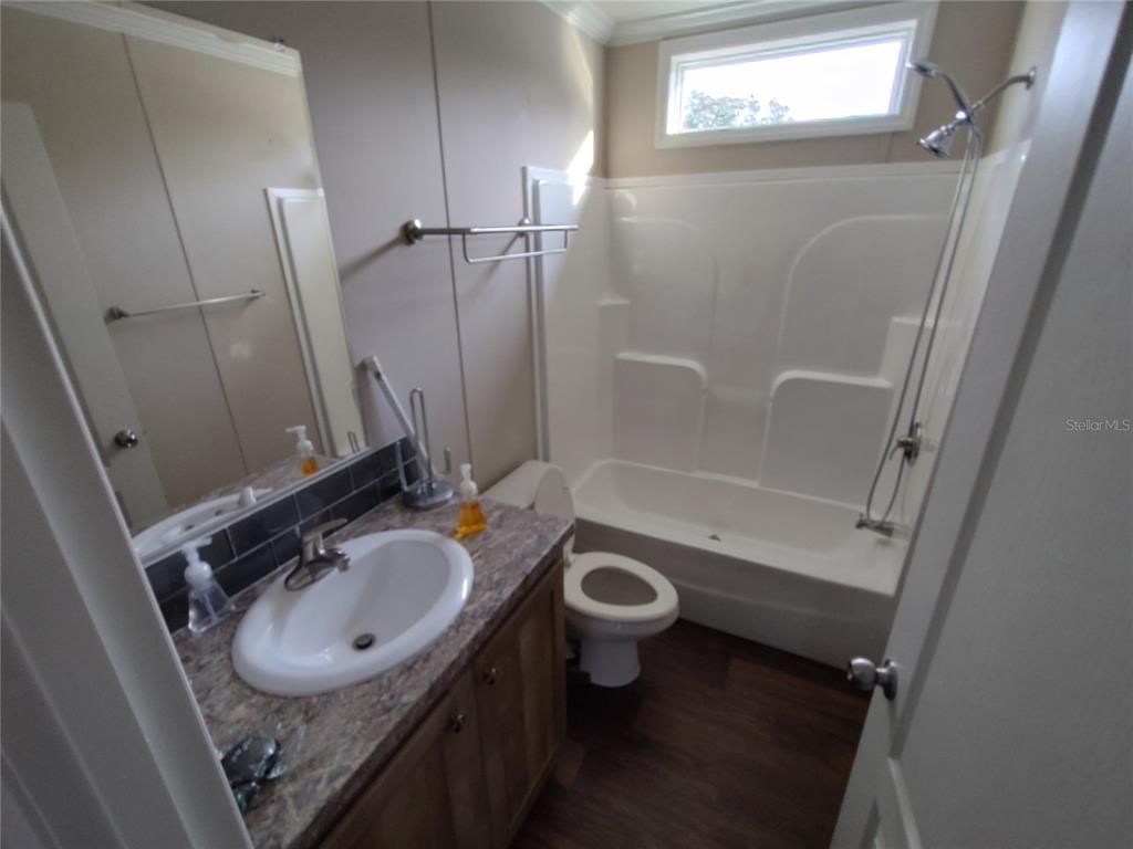 9811 Bud Street Hudson, FL 34669 - Photo 25 of 53 a bathroom with a sink toilet a mirror and shower