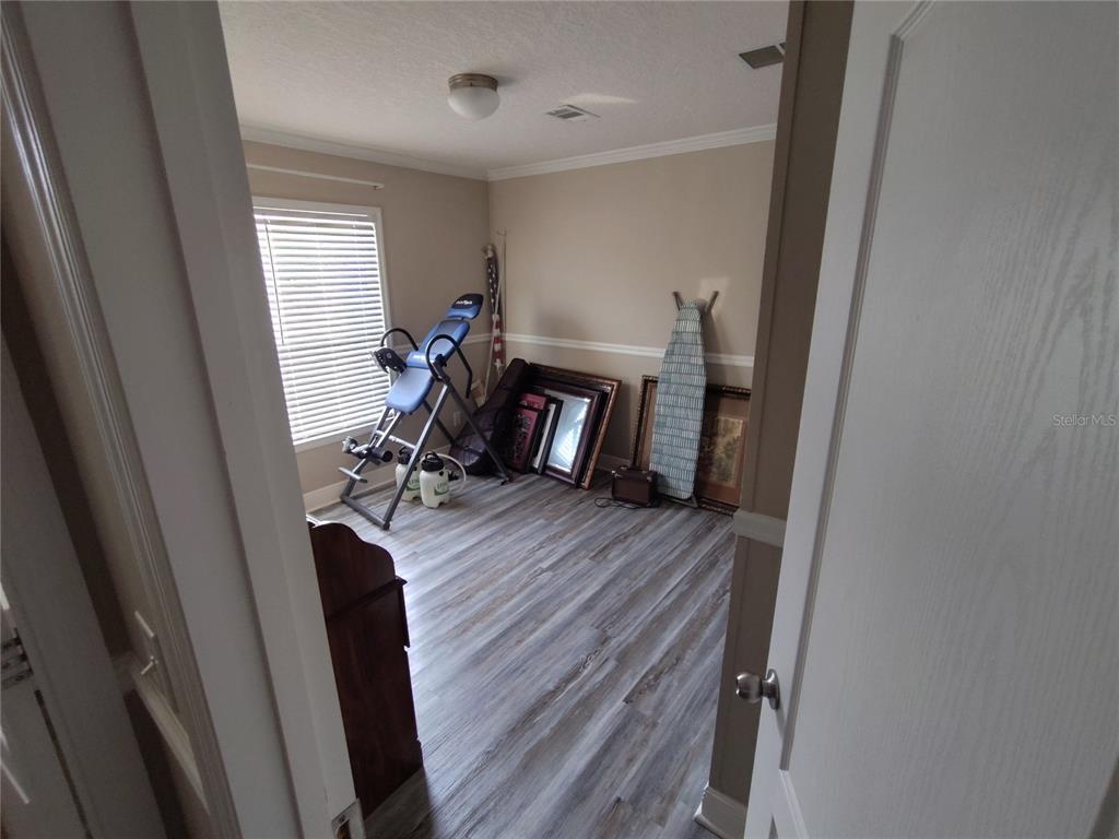 9811 Bud Street Hudson, FL 34669 - Photo 26 of 53 a view of a hallway with wooden floor and furniture