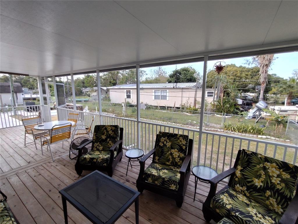 9811 Bud Street Hudson, FL 34669 - Photo 37 of 53 a view of a chairs and table in patio with wooden floor