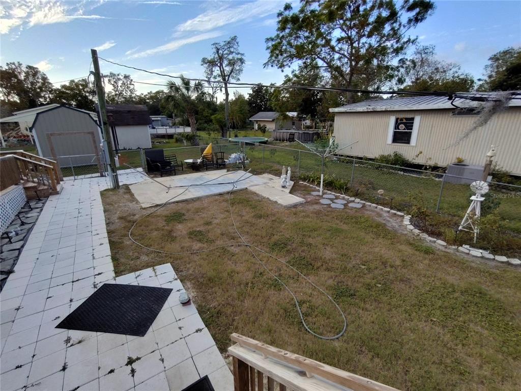 9811 Bud Street Hudson, FL 34669 - Photo 39 of 53 a view of a patio with table and chairs a barbeque with wooden fence