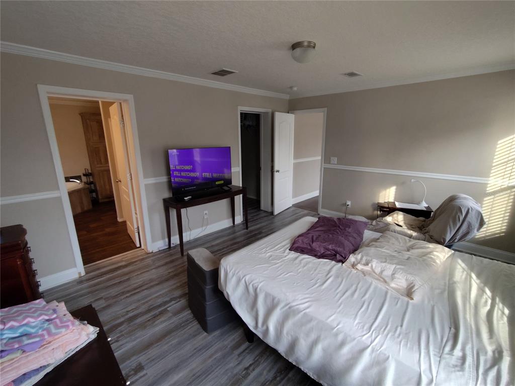 9811 Bud Street Hudson, FL 34669 - Photo 8 of 53 a bedroom with a bed and a flat screen tv