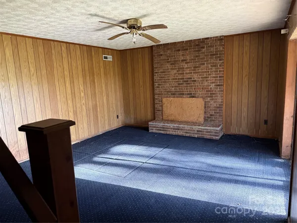 a view of an empty room with wooden floor and windows