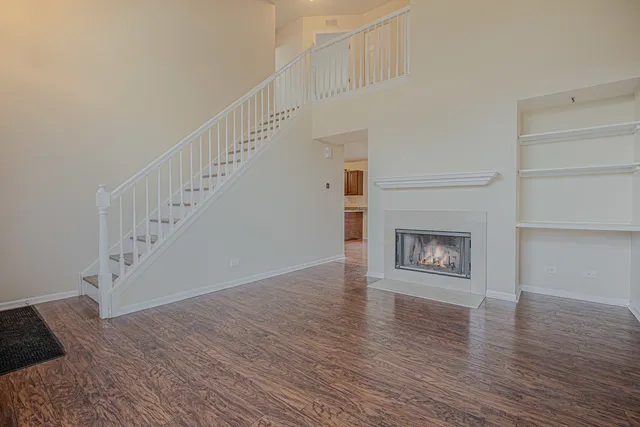 a view of a livingroom with wooden floor and a fireplace