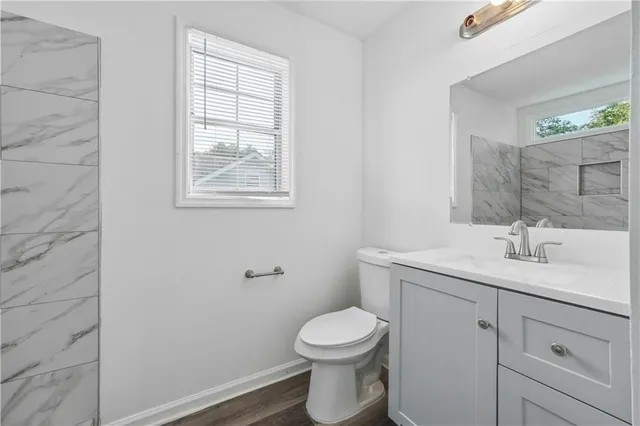 a bathroom with a toilet a sink a vanity and mirror