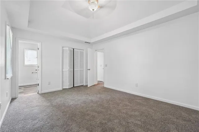 a view of an empty room and chandelier fan