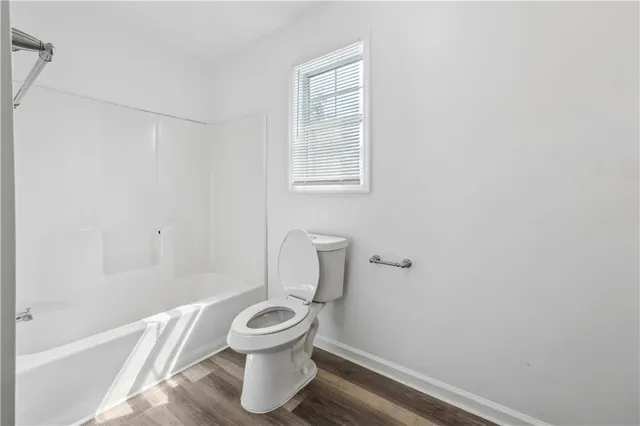 a white toilet sitting next to a bath tub