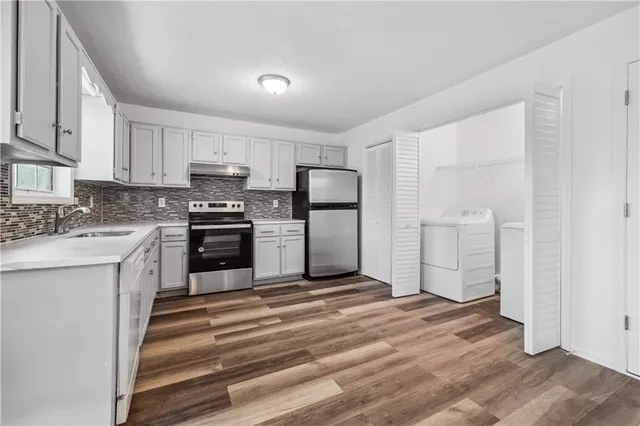 a kitchen with white cabinets and stainless steel appliances