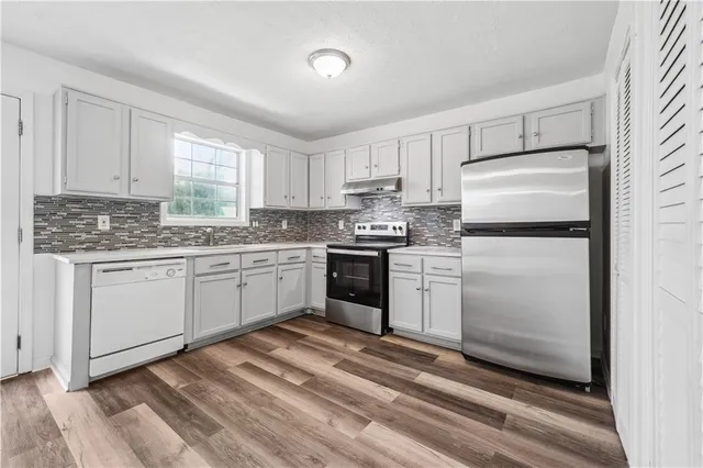 a kitchen with granite countertop white cabinets and white appliances