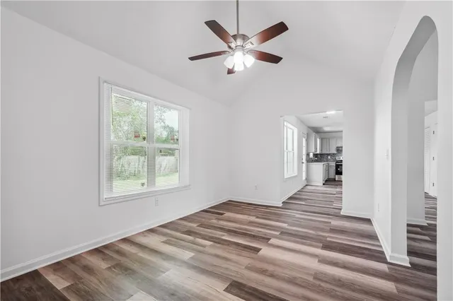 a view of a bedroom with wooden floor and a ceiling fan