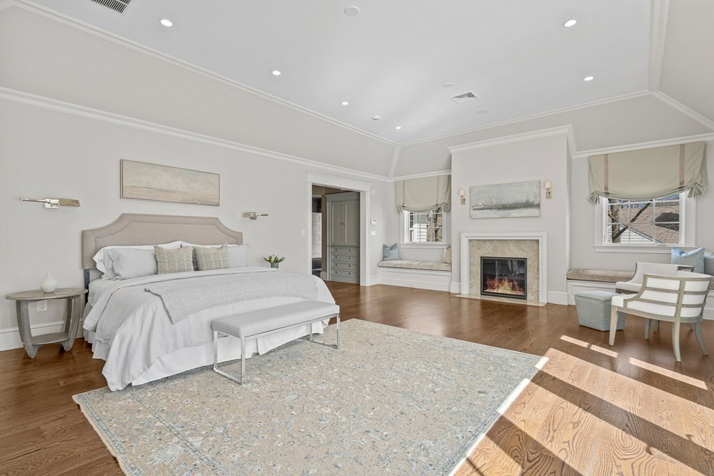 48 Everett Avenue Winchester, MA 01890 - Photo 20 of 42 a spacious bedroom with a large bed a fireplace and a couch