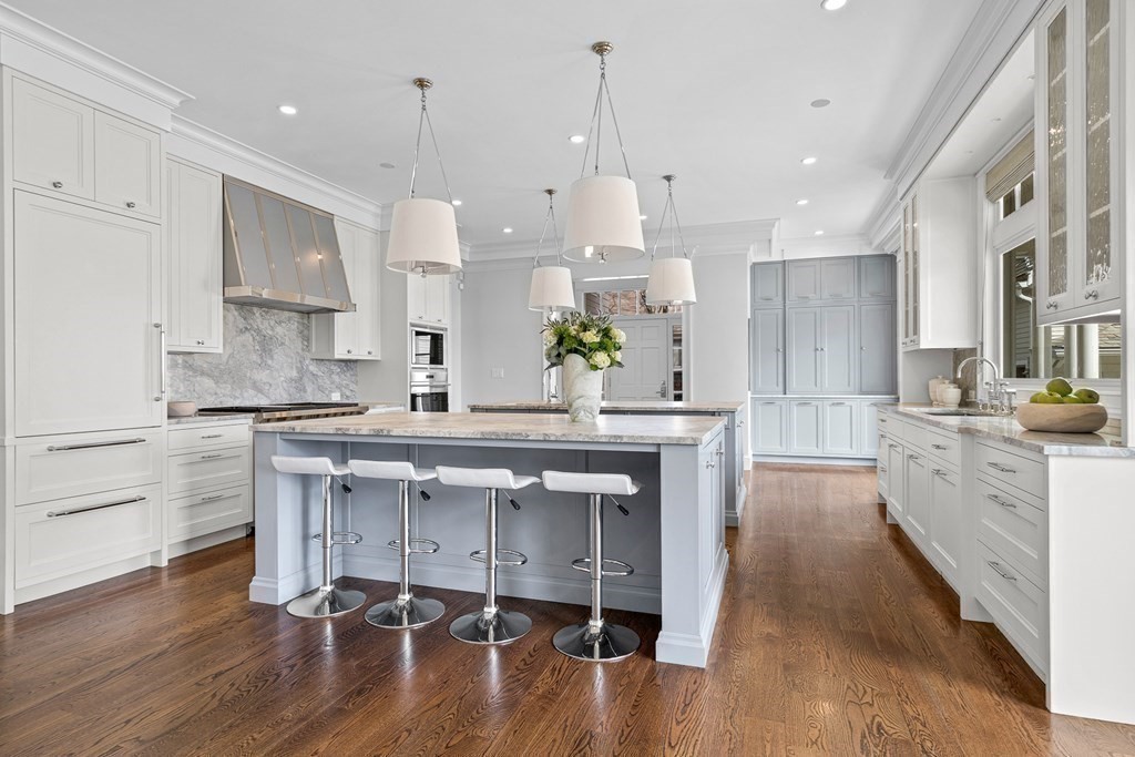 48 Everett Avenue Winchester, MA 01890 - Photo 8 of 42 a large kitchen with cabinets wooden floor and stainless steel appliances