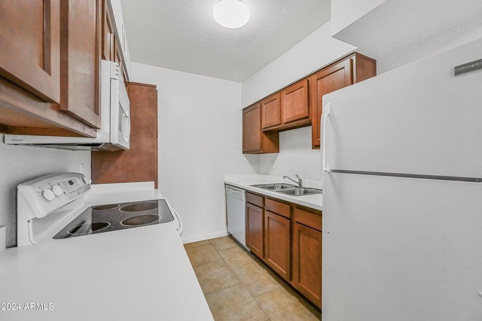 1518 West Colter Street, Unit 10 Phoenix, AZ 85015 - Photo 6 of 14 a kitchen with stainless steel appliances granite countertop a stove and a sink